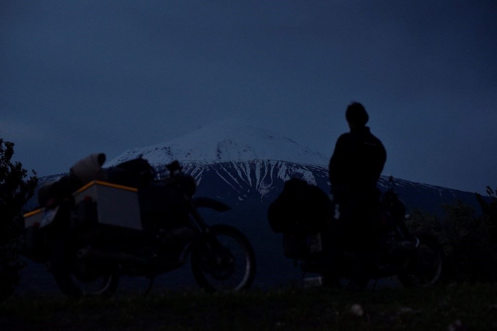 Die beiden Reise-Boxer-Motorräder vor dem schnee bedekten Gipfel.